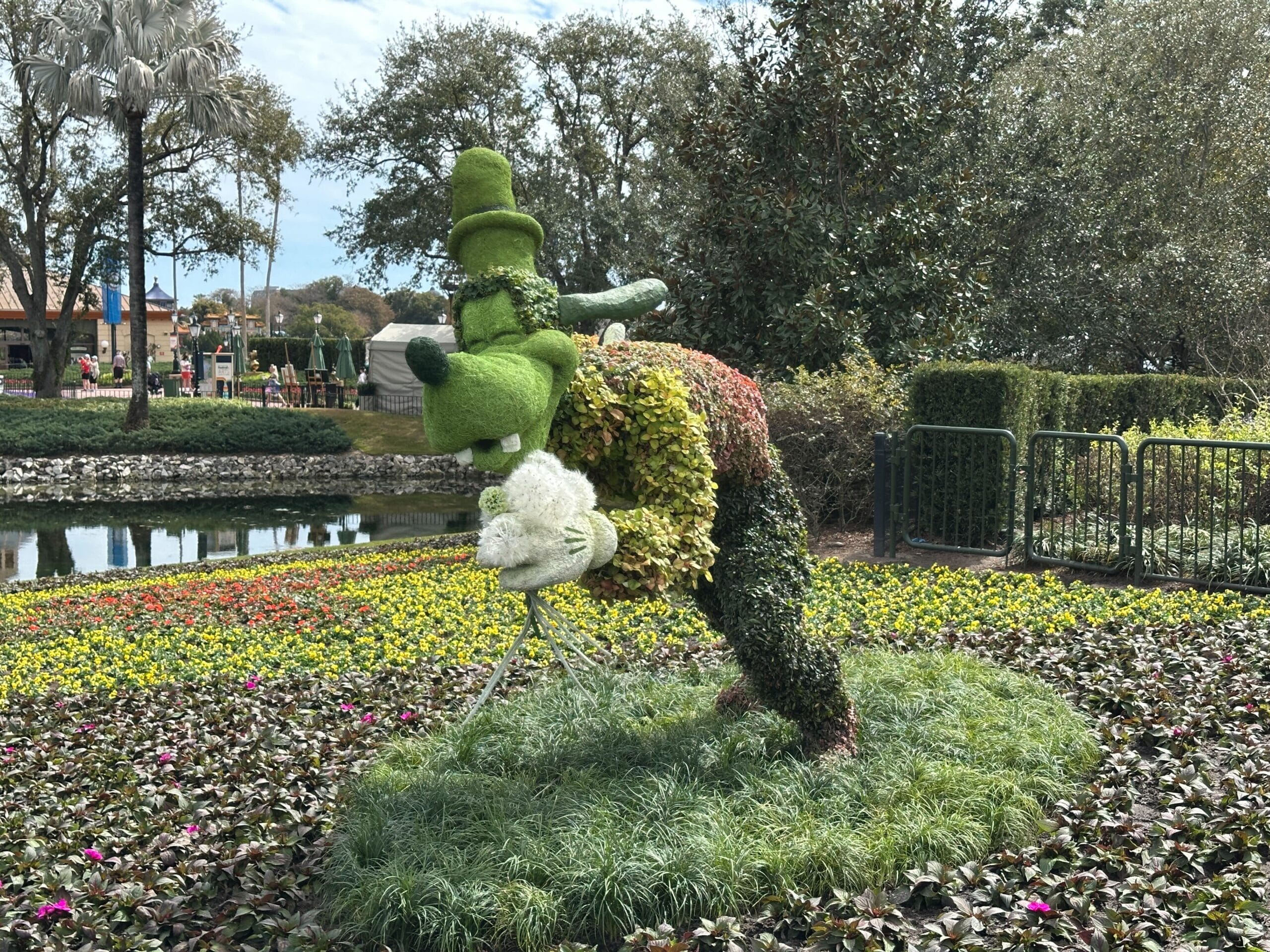 Along the rose walk between the Imagination! Pavilion and World Showcase is Goofy blowing on dandelions.