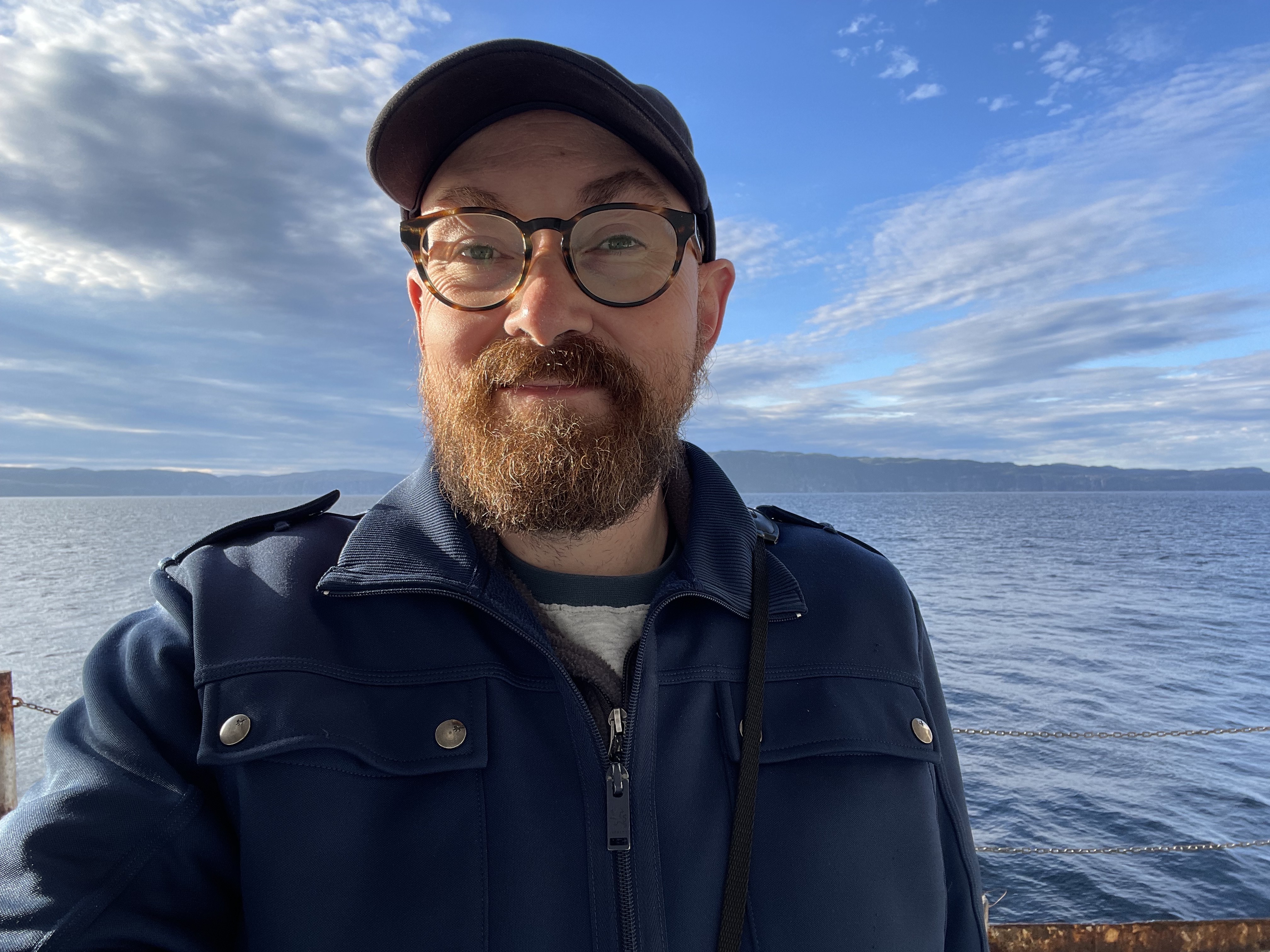 Chad Witko, male ornithologist wearing a cap and blue jacket
