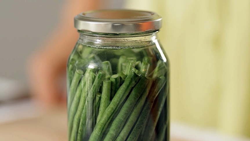A sealed jar of beans in liquid.