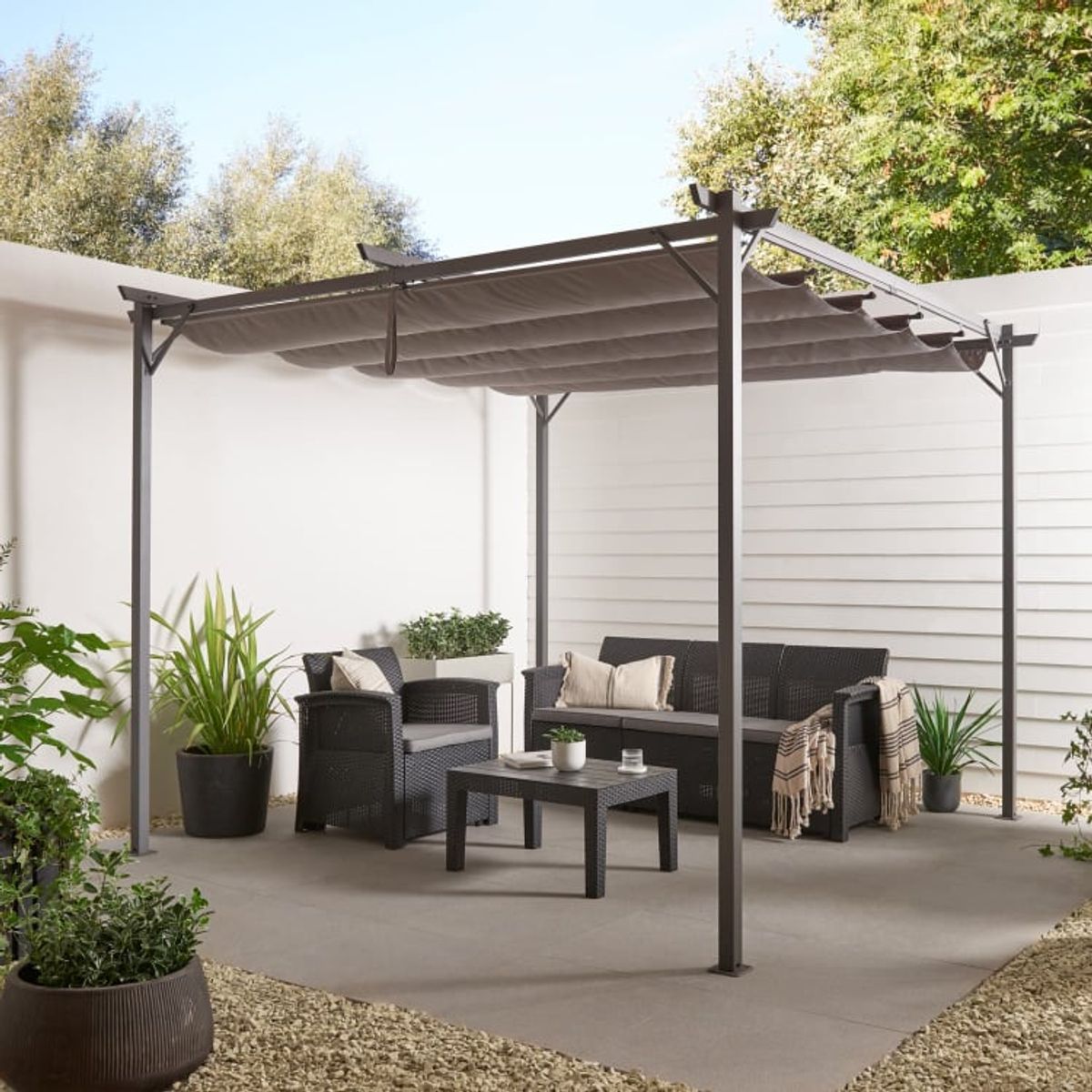 An image of a garden space with furniture and a pergola for shade