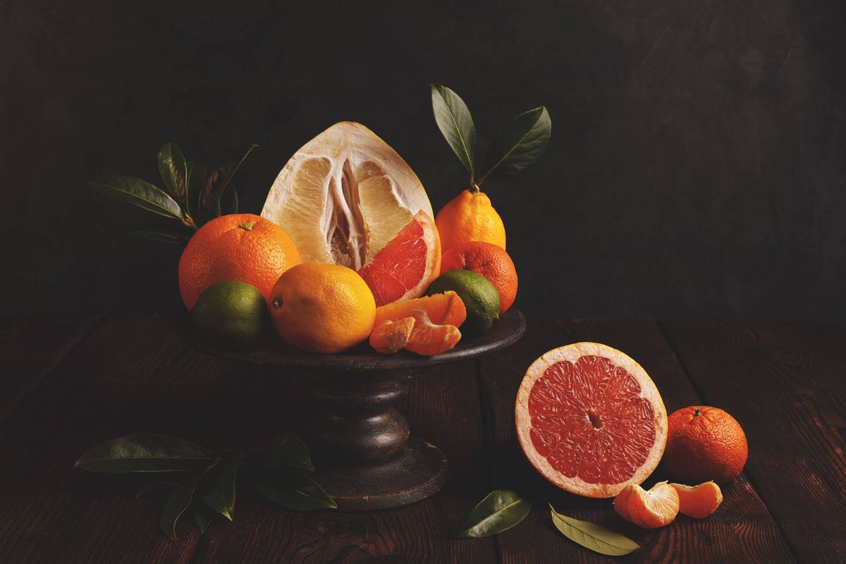 Citrus fruits on a rustic cake stand with leaves