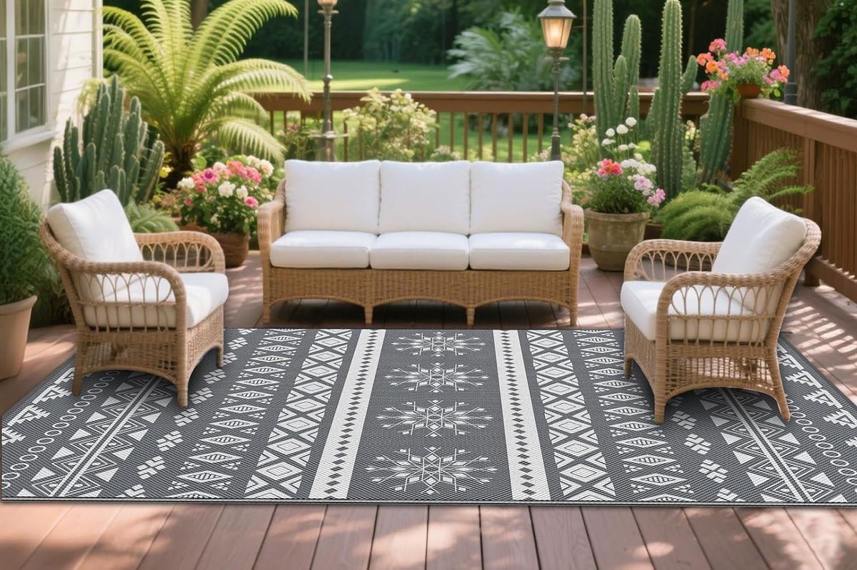 An image of an outdoor garden space with rattan furniture on a patio