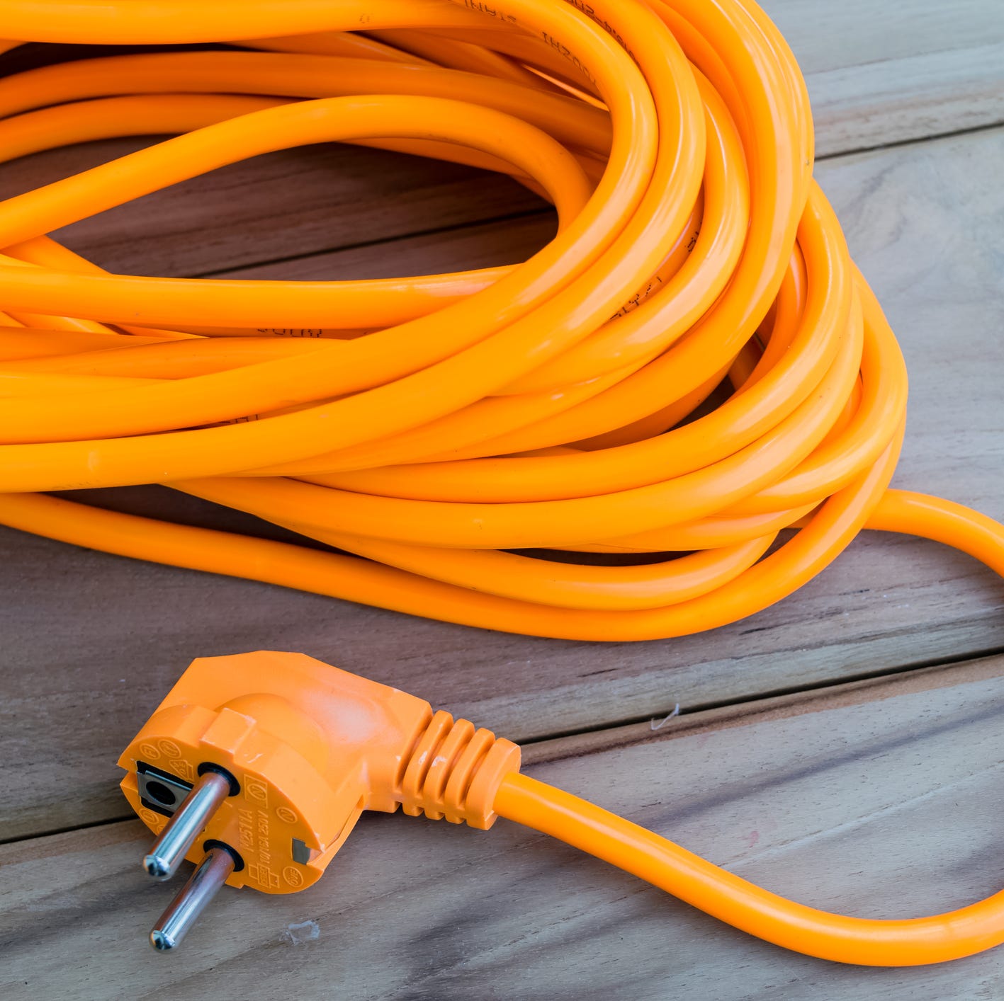 orange extension cord on wood planks