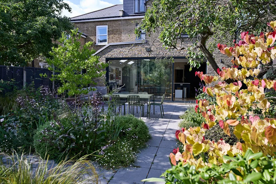 exterior of modern house with chairs and table arranged in back yard