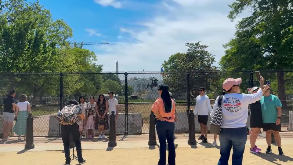 Visitors look at the White House in front of fenced off Lafayette Park while the campus undergoes changes on Saturday. - Riane Lumer/CNN