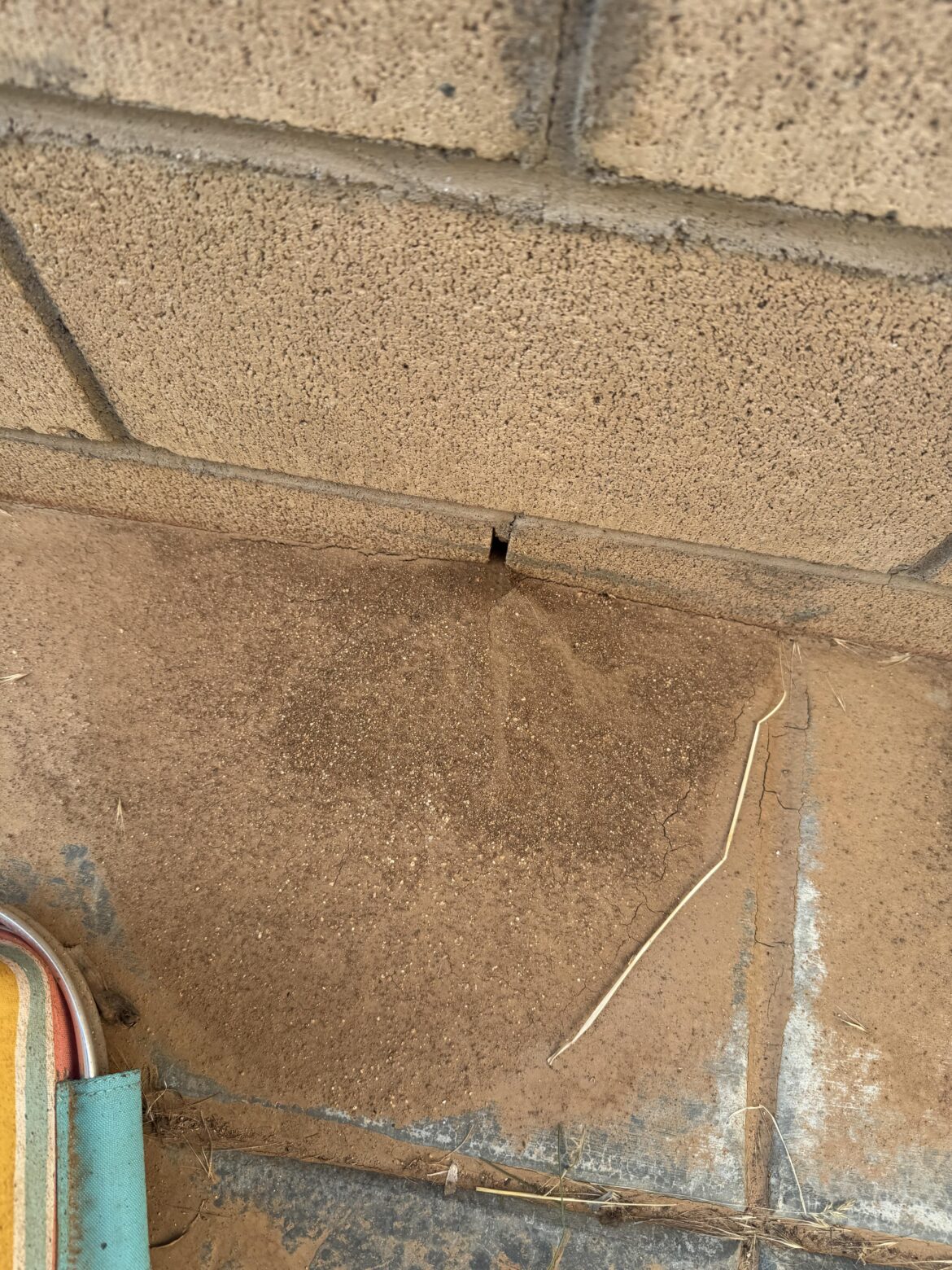 How do I stop dirt from seeping at bottom of retaining wall