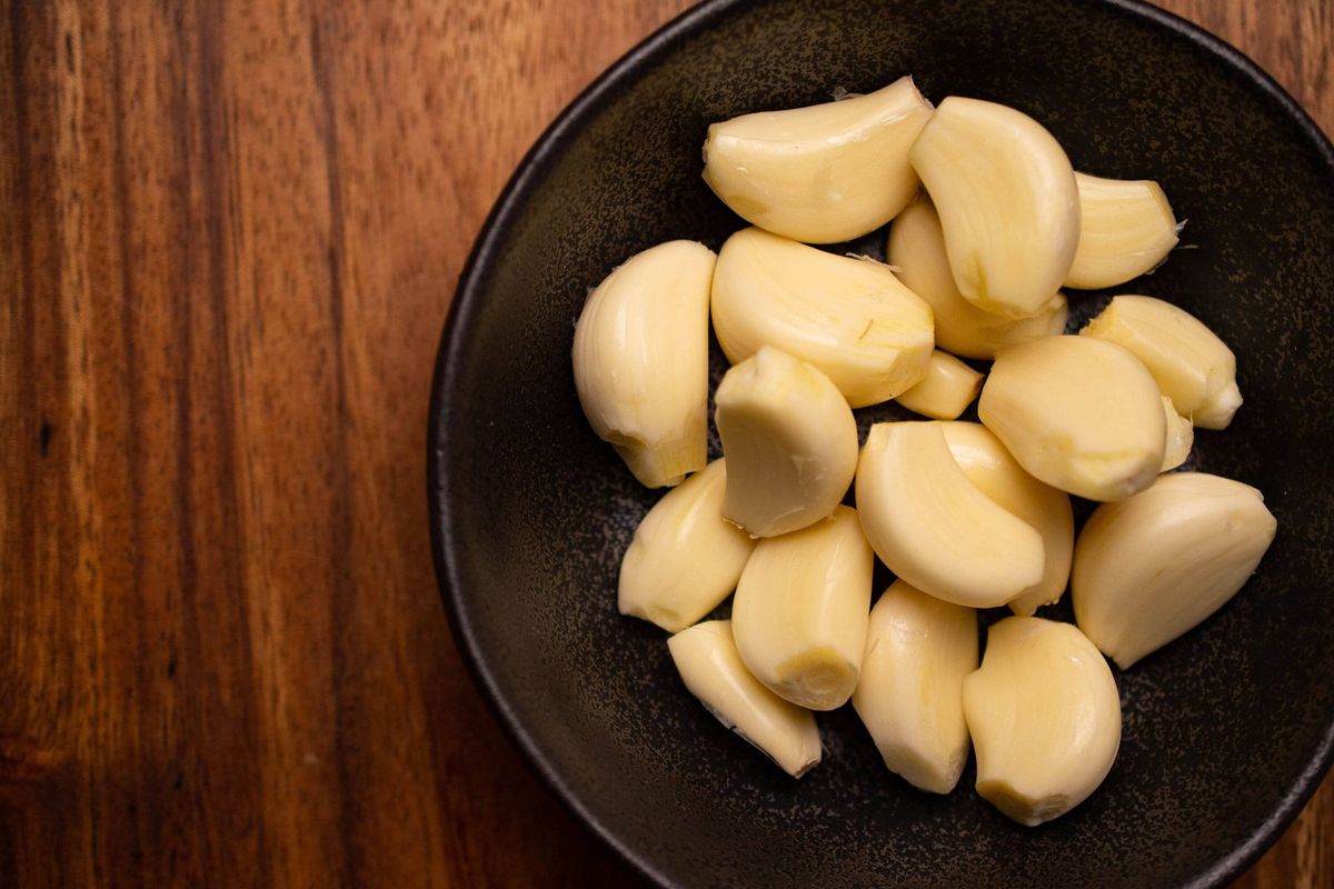 Peeled Garlic Bulbs in Rustic Bowl on Kitchen Counter