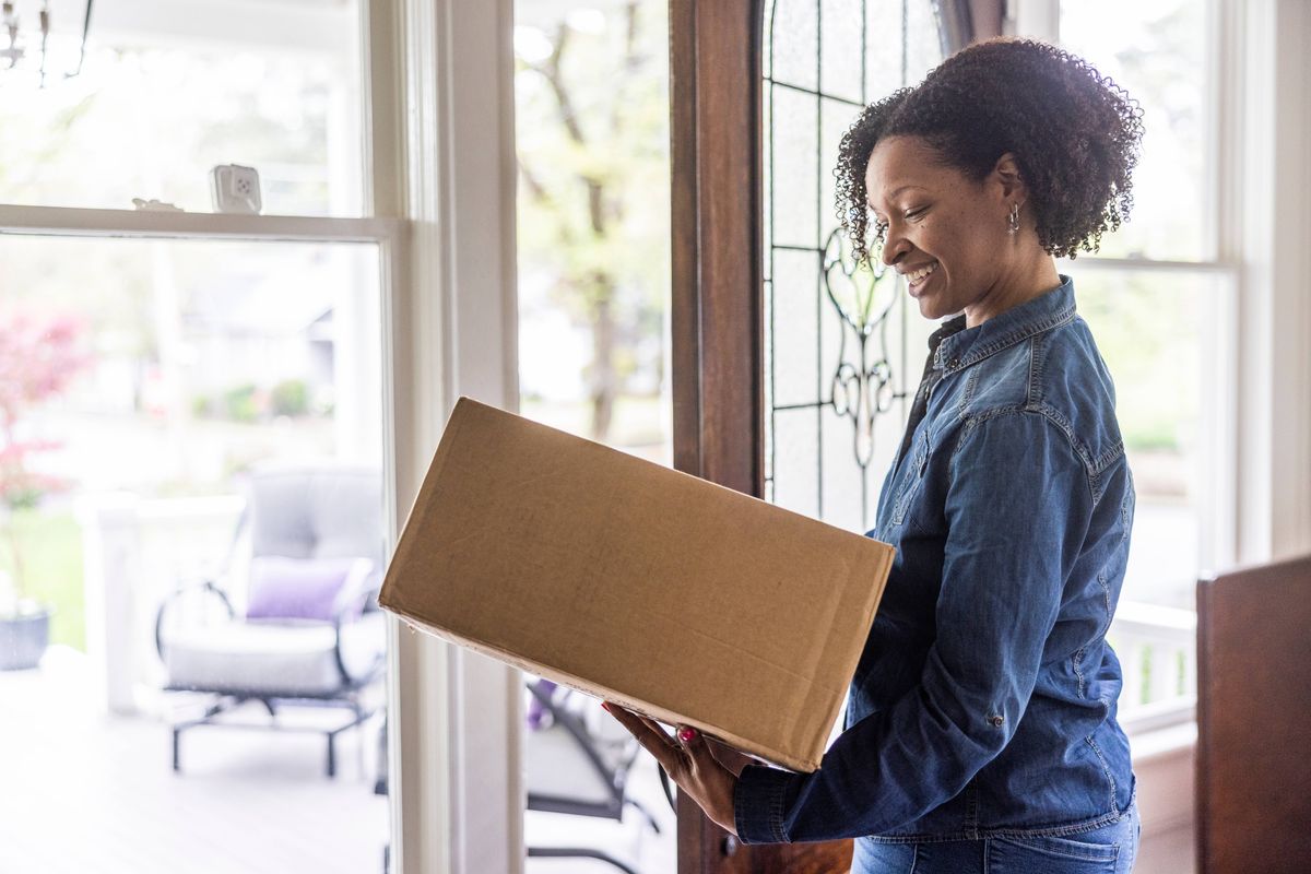 Woman receiving delivered package at home