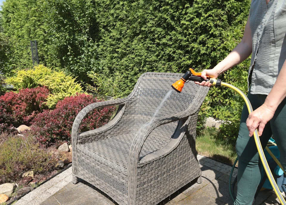 Hosing wicker furniture in summer (Alamy/PA)