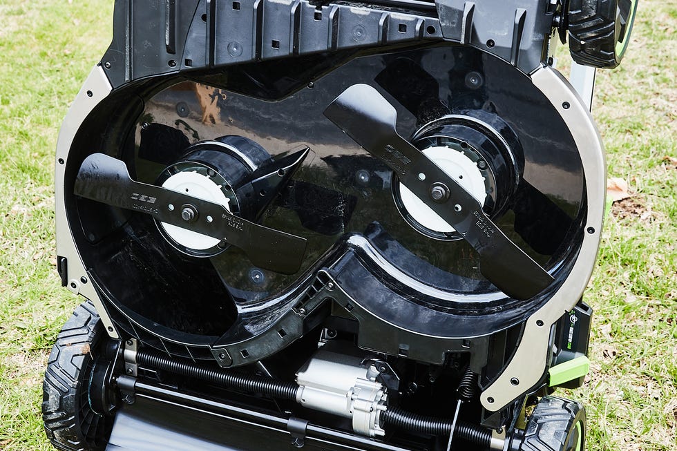 Underside view of a lawn mower showing its blade assembly and motor.