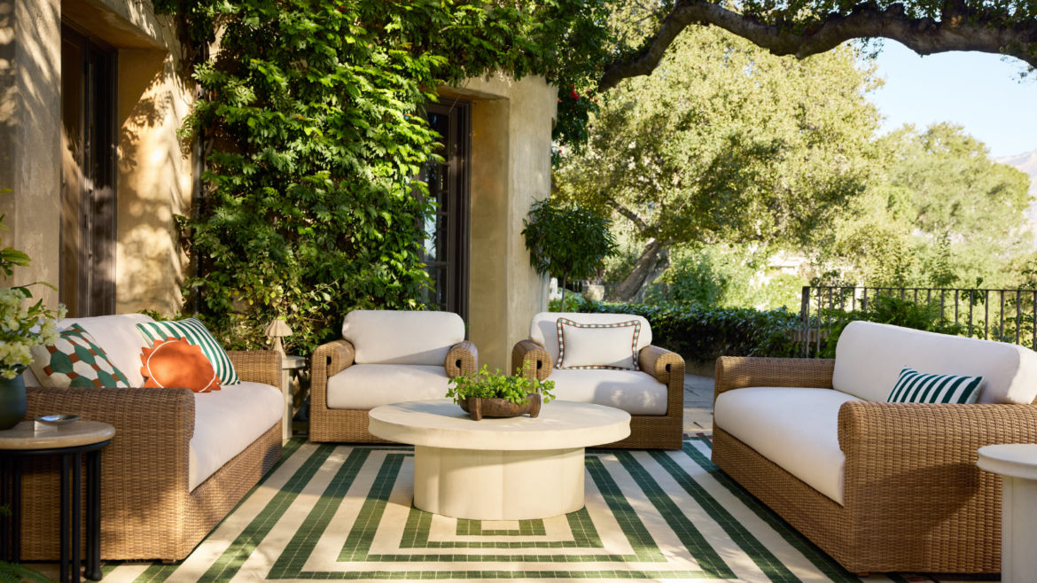 5 Outdoor Furniture Trends Bringing Personality to Patios an outdoor patio with a striped rug, a round ottoman, two sofas, two accent chairs, and decorative pillows