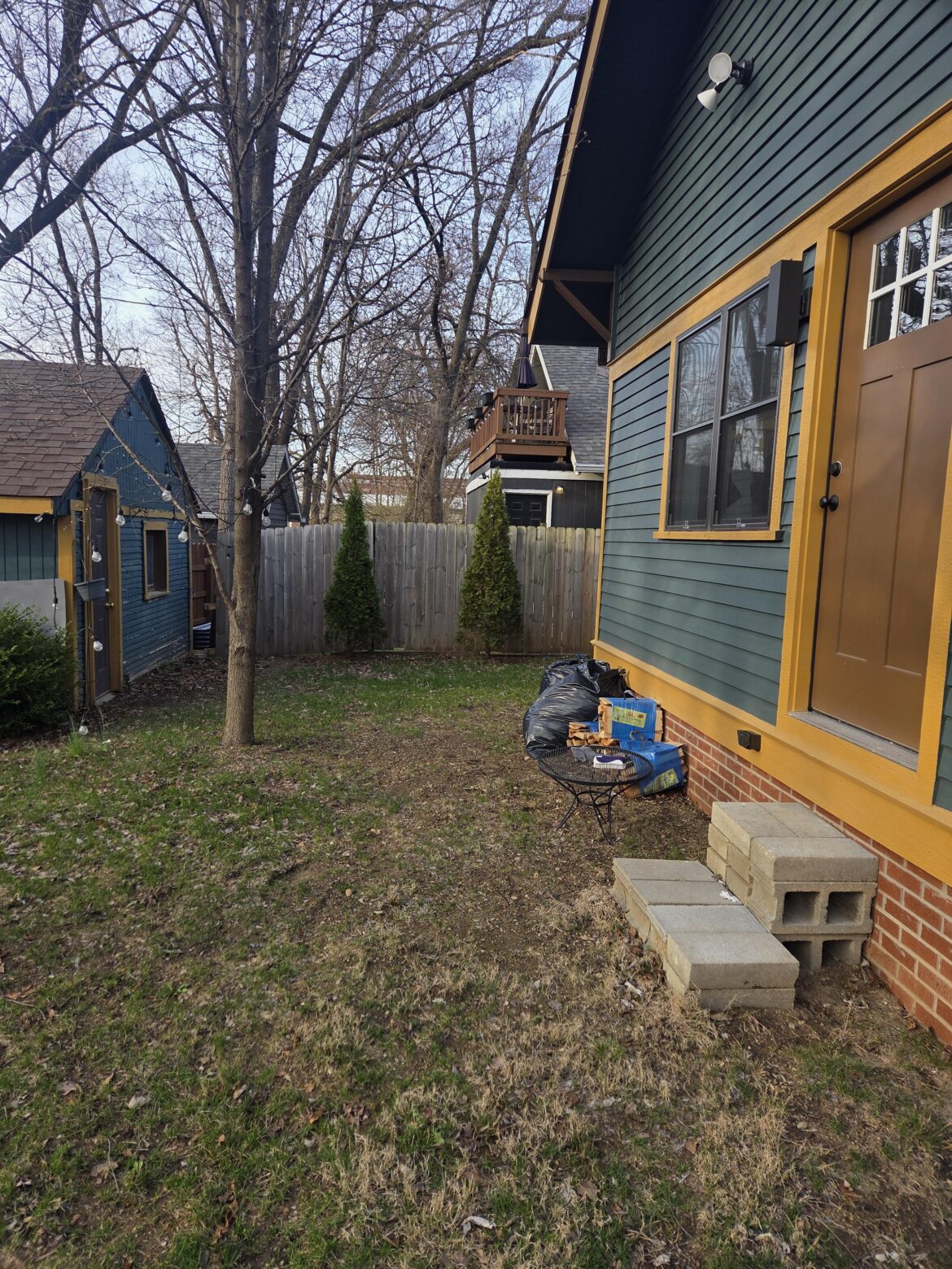 Wanted to hardscape a patio and the first thing three different landscapes said was some variation of “what idiot put this tree here”. It’s 8 feet from the house and 5 feet from the garage. The lack of stairs to the backdoor is on the list. Should I remove it? It’s as tall as the house now. Wanted to hardscape a patio and the first thing three different landscapes said was some variation of "what idiot put this tree here". It's 8 feet from the house and 5 feet from the garage. The lack of stairs to the backdoor is on the list. Should I remove it? It's as tall as the house now.