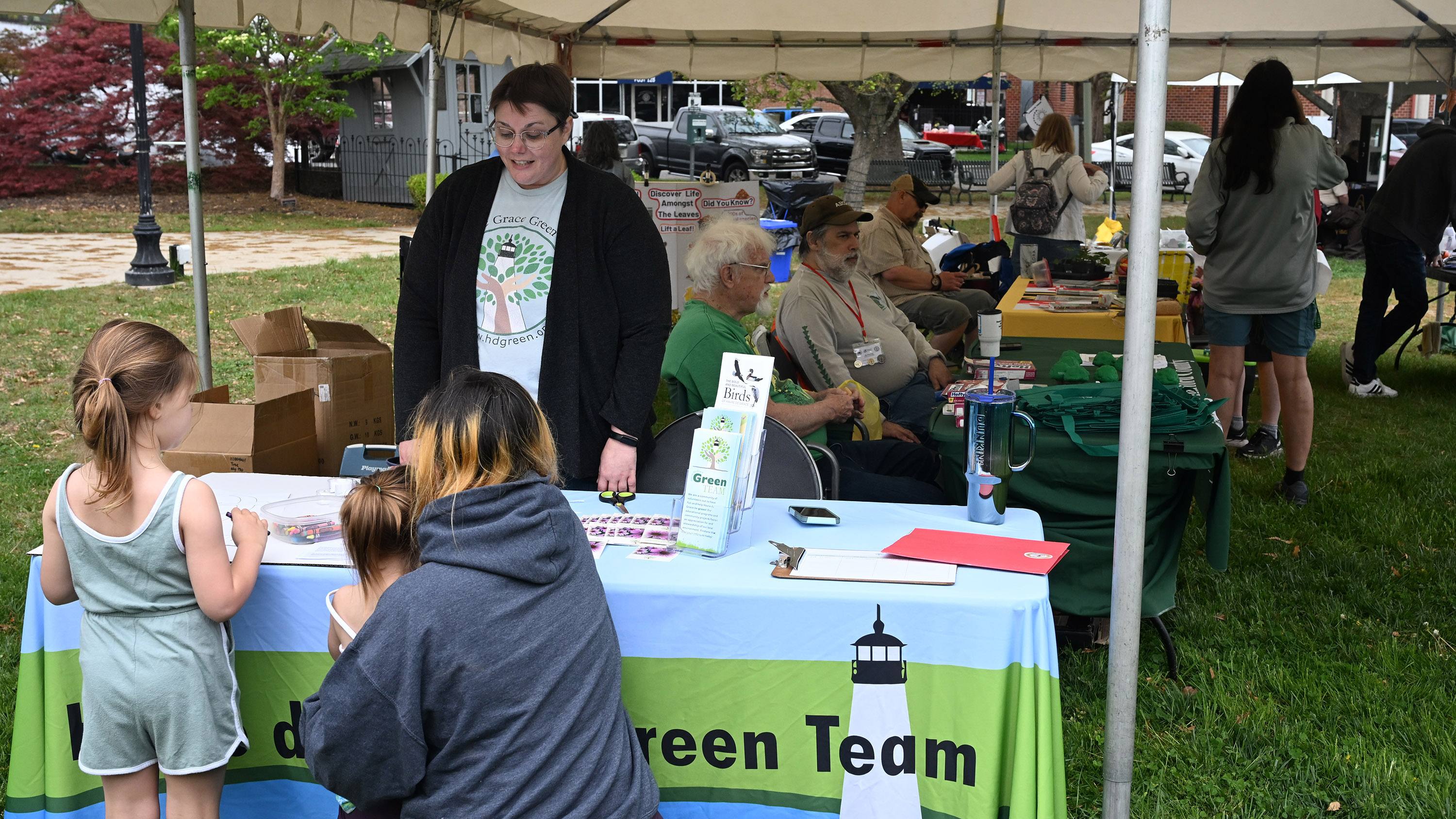 Danielle Wolfe, president of Havre de Grace Green Team, teaches a family about the group's activities while helping them with a craft during the Earth Day celebration at Festival Park in Aberdeen on Saturday. (Brian Krista/Staff)