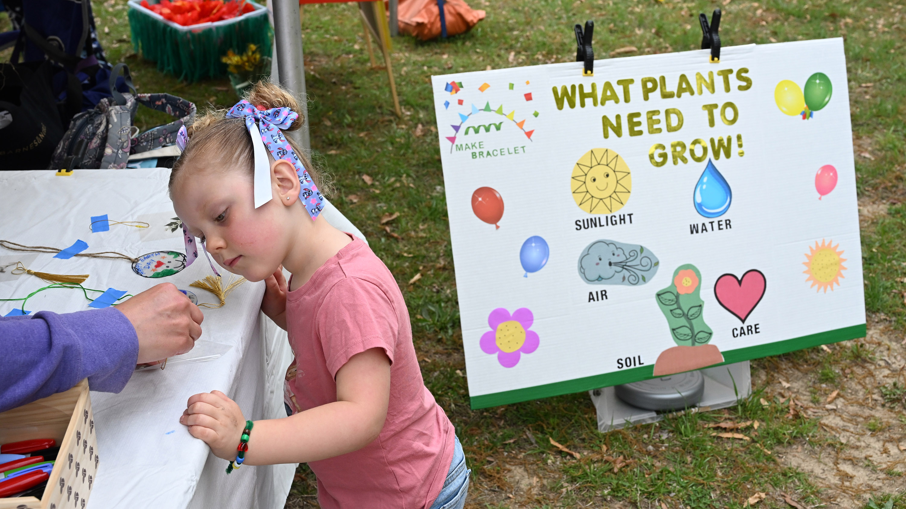 Four-year-old Alison Walker of Aberdeen gets a hand making a craft from a Harford County Master Gardener during the Earth Day celebration at Festival Park in Aberdeen on Saturday. (Brian Krista/Staff)