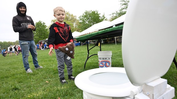 Kamren Merritt, 6, of Edgewood is accompanied by his father Daris while playing a game during the Earth Day celebration at Festival Park in Aberdeen on Saturday. (Brian Krista/Staff)