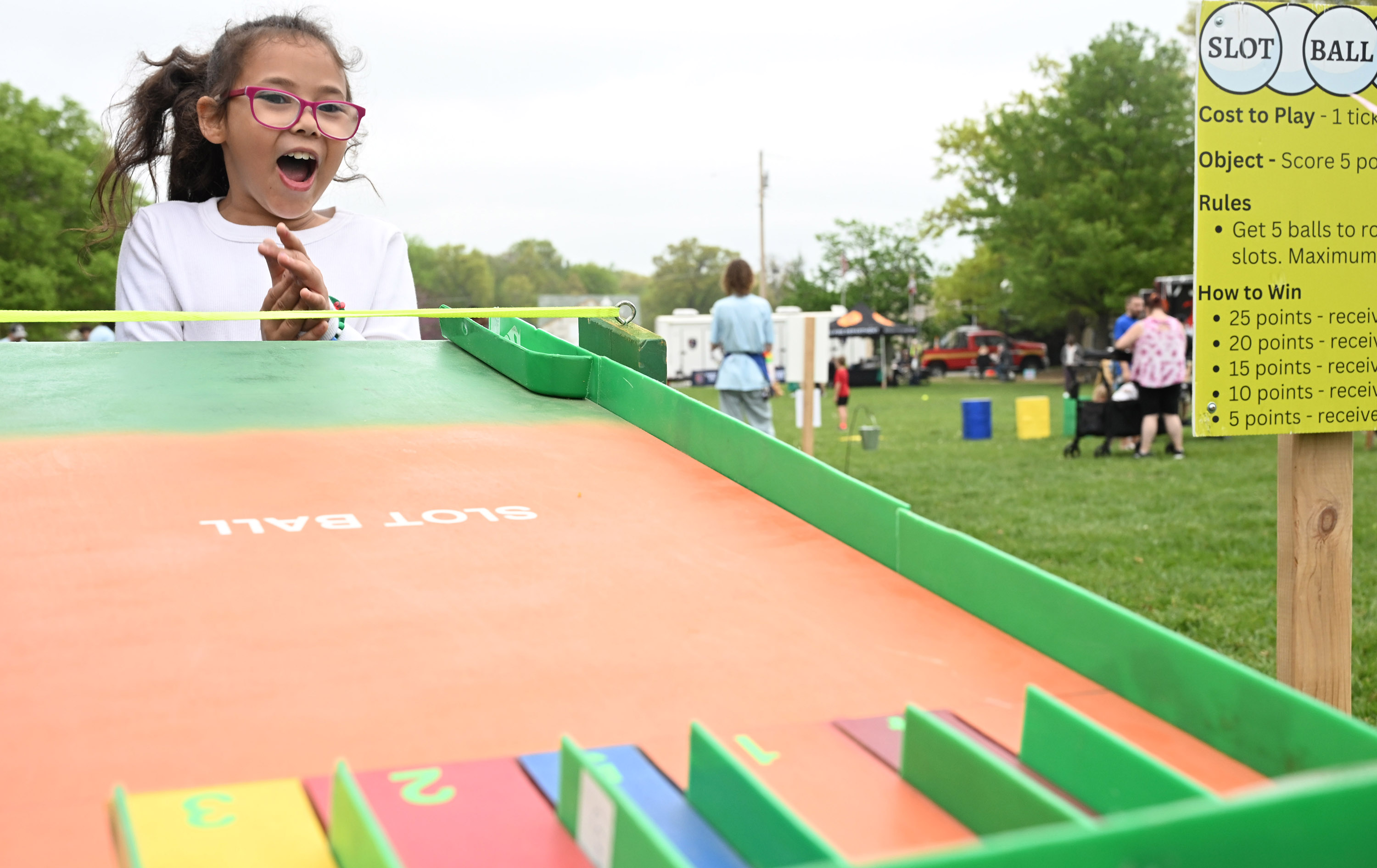 Sophia McAfee, 7, of Aberdeen shows her excitement as she plays a game made from repurposed materials during the Earth Day celebration at Festival Park in Aberdeen on Saturday. (Brian Krista/Staff)