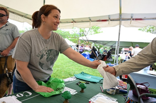 Amber Mallory of Abingdon accepts a free native tree seedling from a member of the Harford County Forestry Board during the Earth Day celebration at Festival Park in Aberdeen on Saturday. (Brian Krista/Staff)