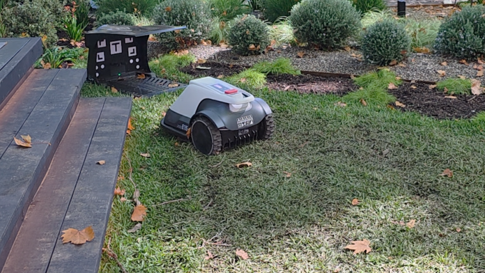 Robot lawn mower backing up from it's housing.