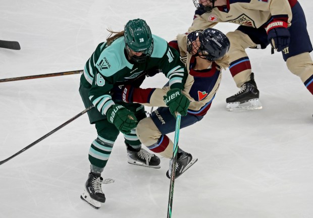 Boston Fleet defenseman Riley Brengman, left, checks Montréal Victoire forward Dara Greig at the TD Garden. (Staff photo by Stuart Cahill/Boston Herald)
