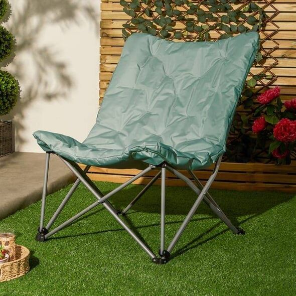 A green folding outdoor chair in a garden
