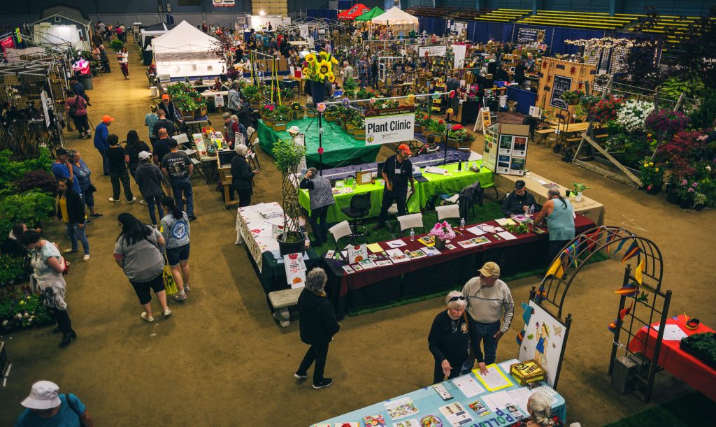 people milling around the tables and tents inside a building at the Grays Harbor Home and Garden Show