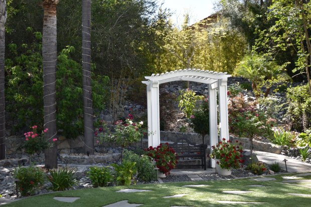 Roses and other flowering varieties are among the more than 2,500 plants in the Garnier garden. The couple said this arbor area is a popular spot for guests to take photos. (Elizabeth Marie Himchak)