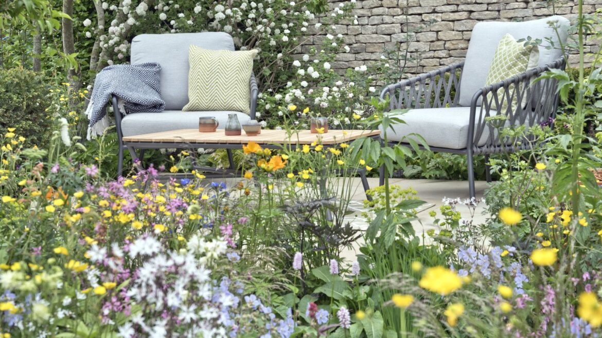 ALDI’s Foldable Garden Rocking Chair Is the Backyard Upgrade to Have A colourful flower bed in front of a paved seating area in a garden