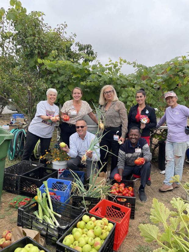 Volunteers stand in the garden after harvesting its produce for donation. (Courtesy CommonSpirit Health)