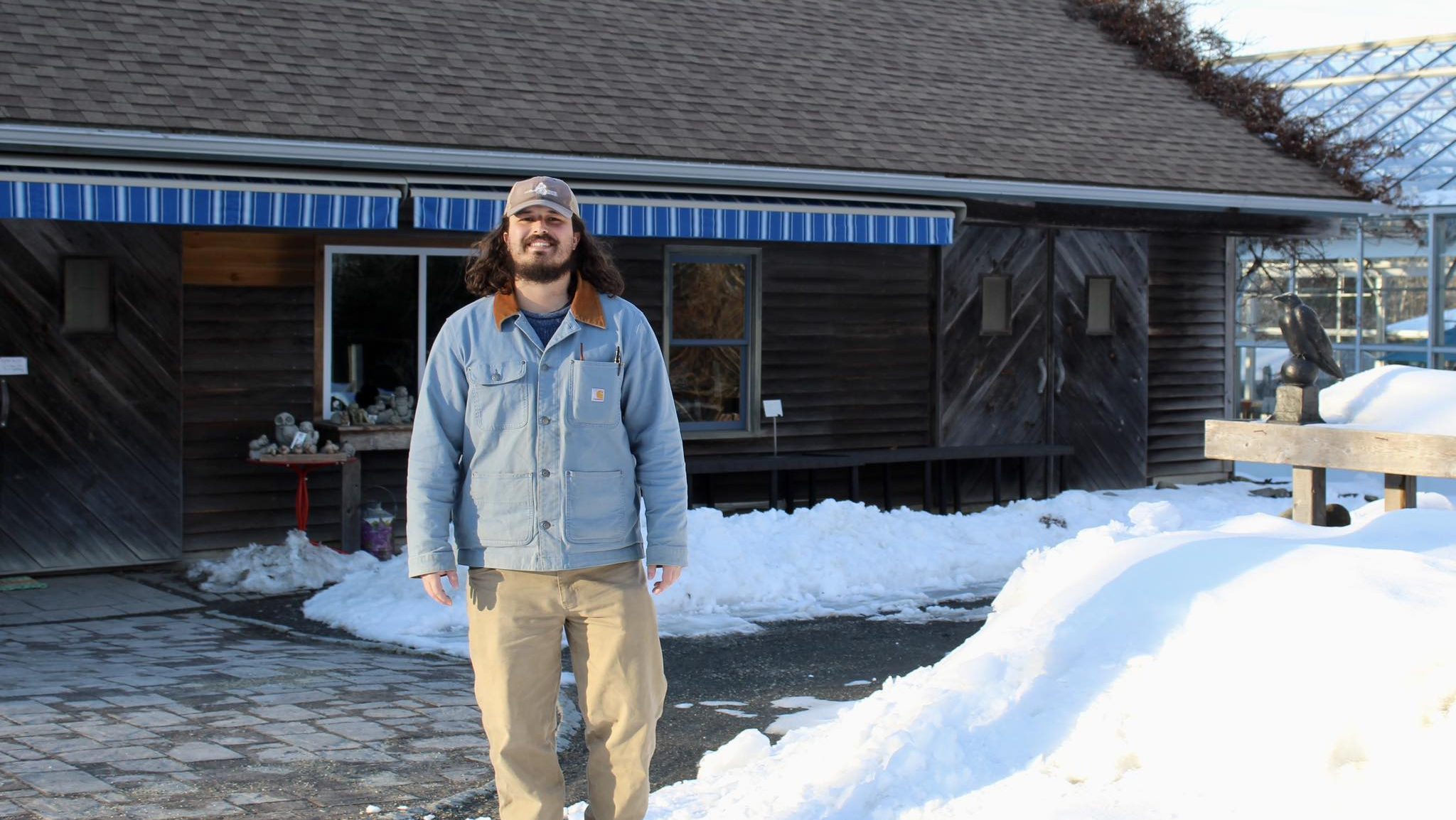 A person stands in front of a buliding.