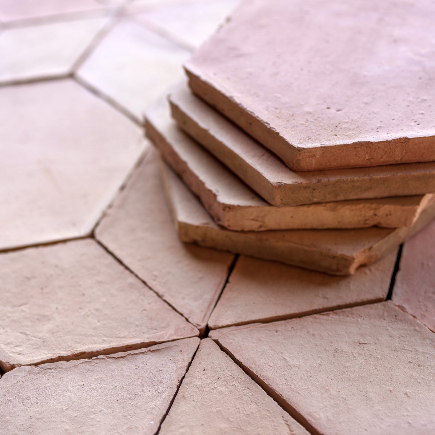 stack of terracotta tiles laying on a tiled floor