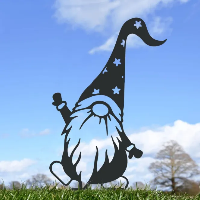 A black metal silhouette of a gnome wearing a pointed, star-patterned hat, with a long beard, gloves, and small boots, standing in grass against a blue sky.