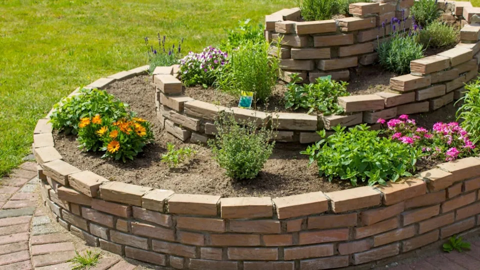 herb spiral in the garden with herbs and flowers