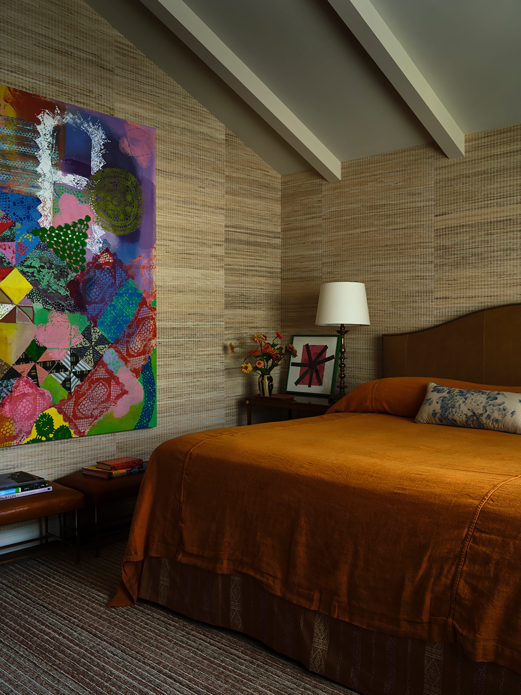 Bedroom featuring an artistic wall decoration and a cozy bed.