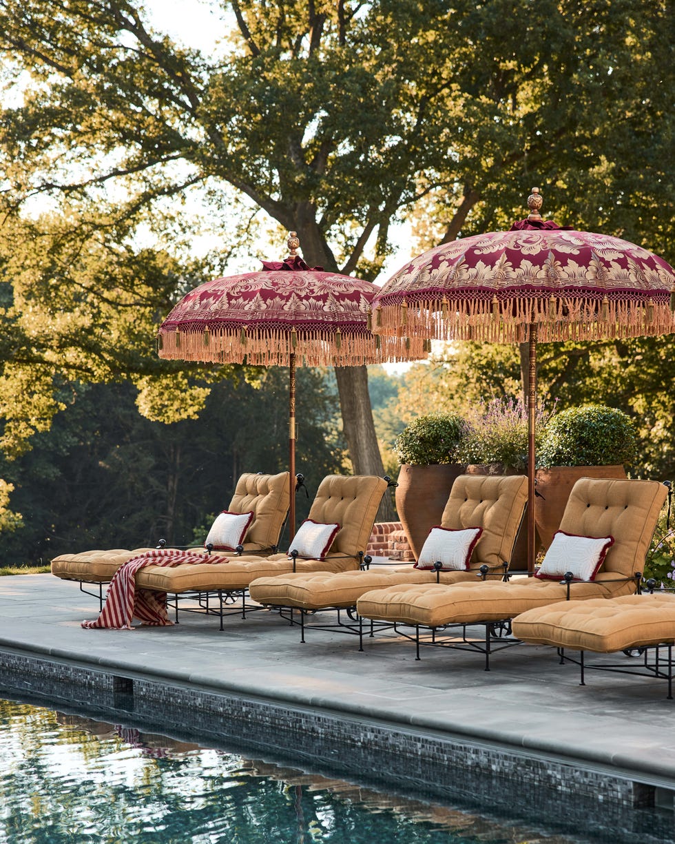 Lounge chairs with umbrellas by a swimming pool. Lounge chairs with umbrellas by a swimming pool.