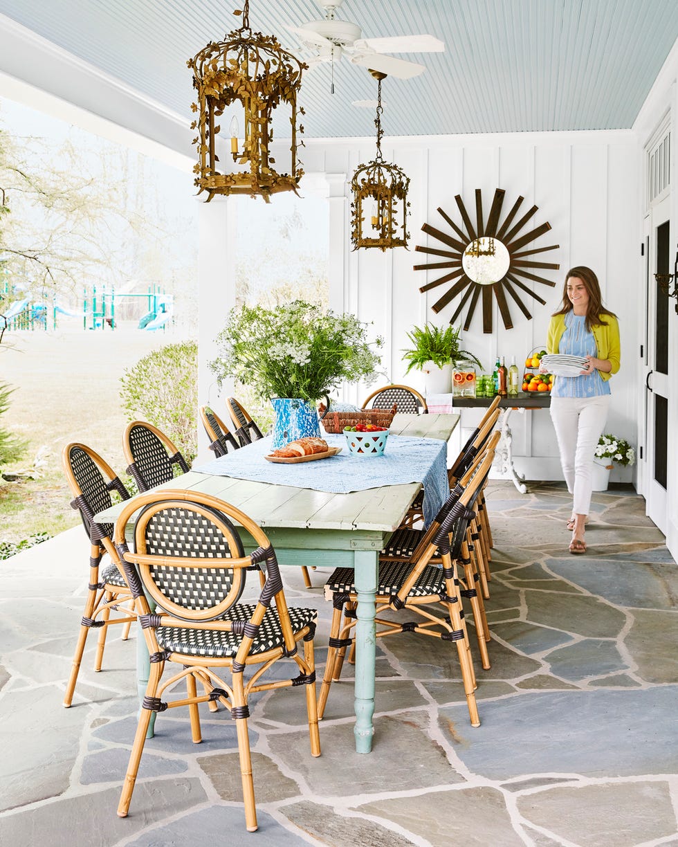 chenault james porch covered outdoor dining room with long table, black and white bistro chairs