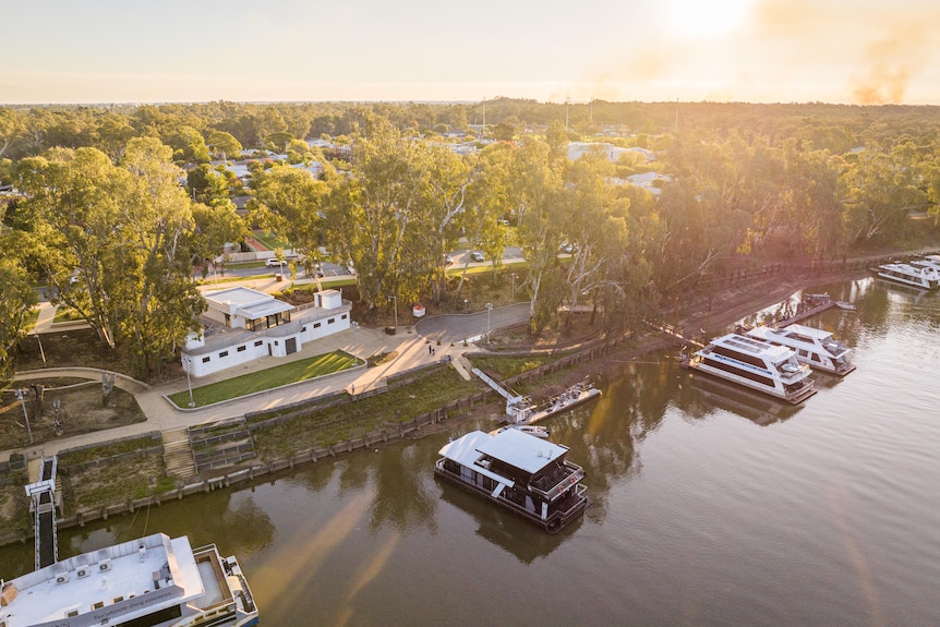 A town along a rive with boats parked near the shore. 