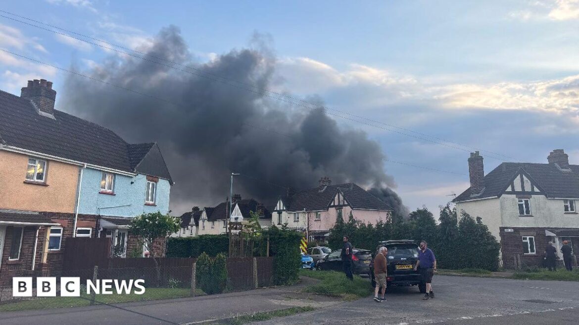 Huge plume of smoke as crews tackle Lydney garden fire A large plume of black smoke coming from a house on Jubilee Road in Lydney. The photo has been taken on a cloudy evening. There are some people standing by some cars on the street.