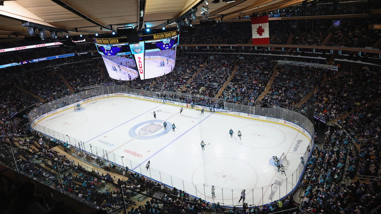 A wide shot showing a large crowd attending a women's hockey game at Madison Square Garden in New York City.