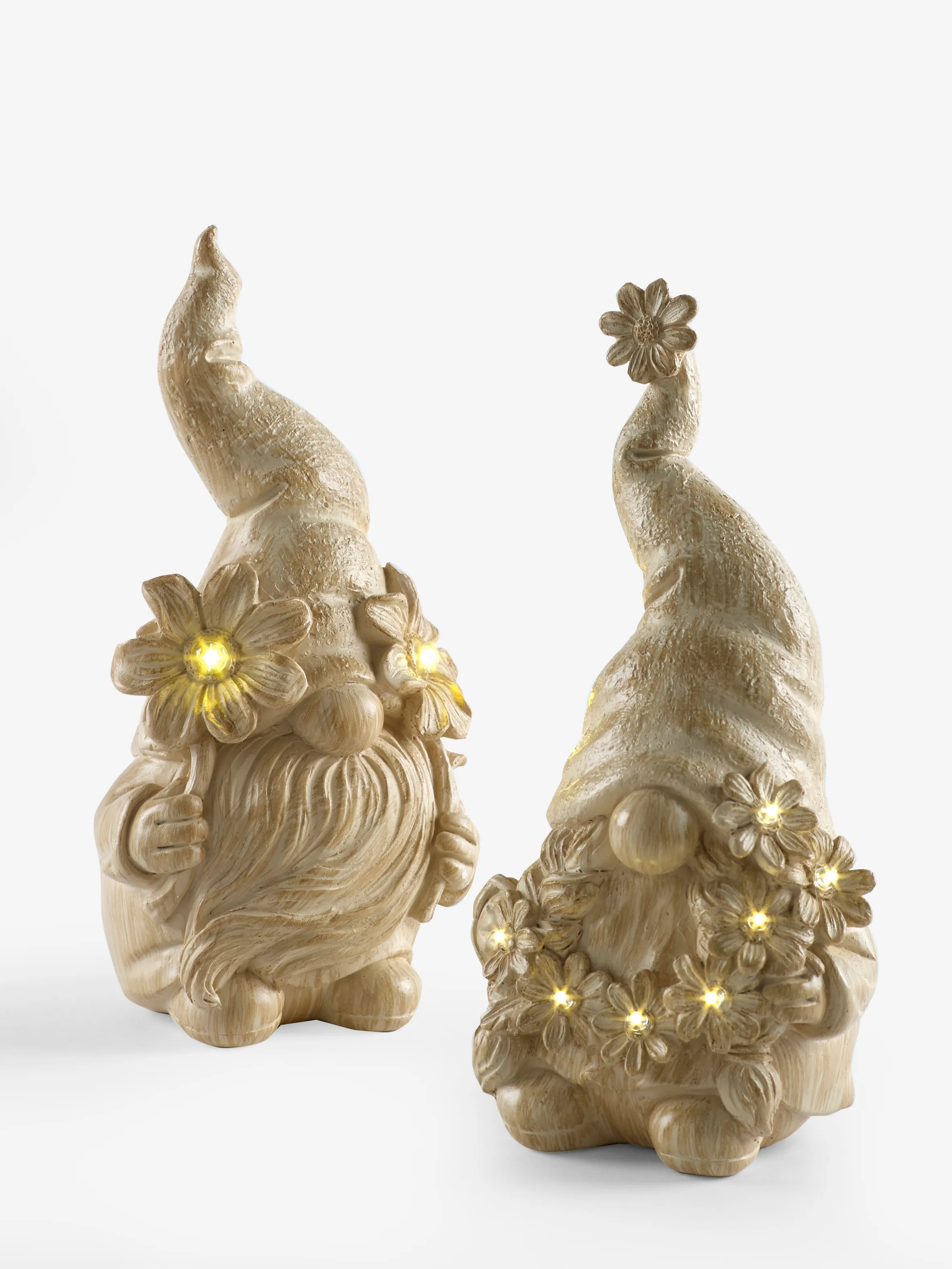 Two solar Gonks, finished in a concrete effect, with decorative flowers and lights.