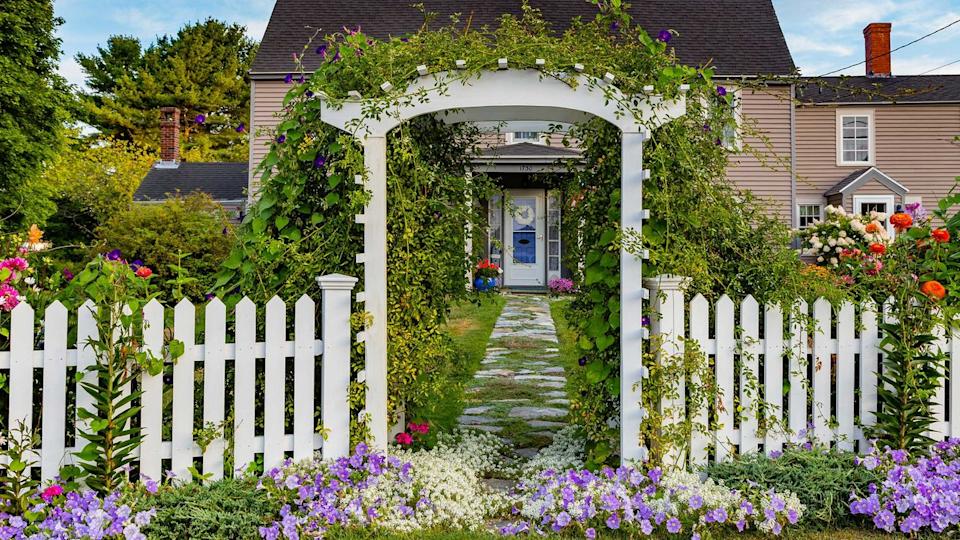 White fence and gate with garden arch.