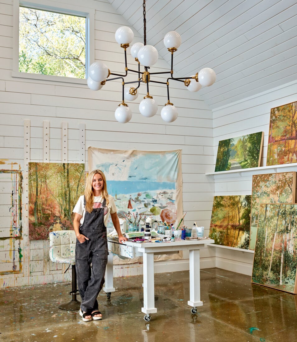 A woman inside an art studio with paintings