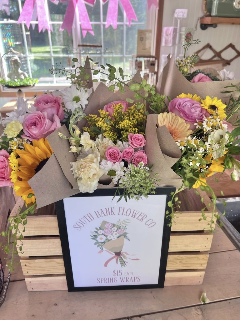a wooden crate full of flower bouquets wrapped in paper. 