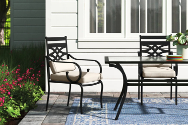 Table and chairs on patio near house and plants