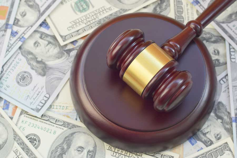 Eagle man sentenced for defrauding Garden City business, IRS A wooden gavel rests on a sound block atop a bed of United States currency.