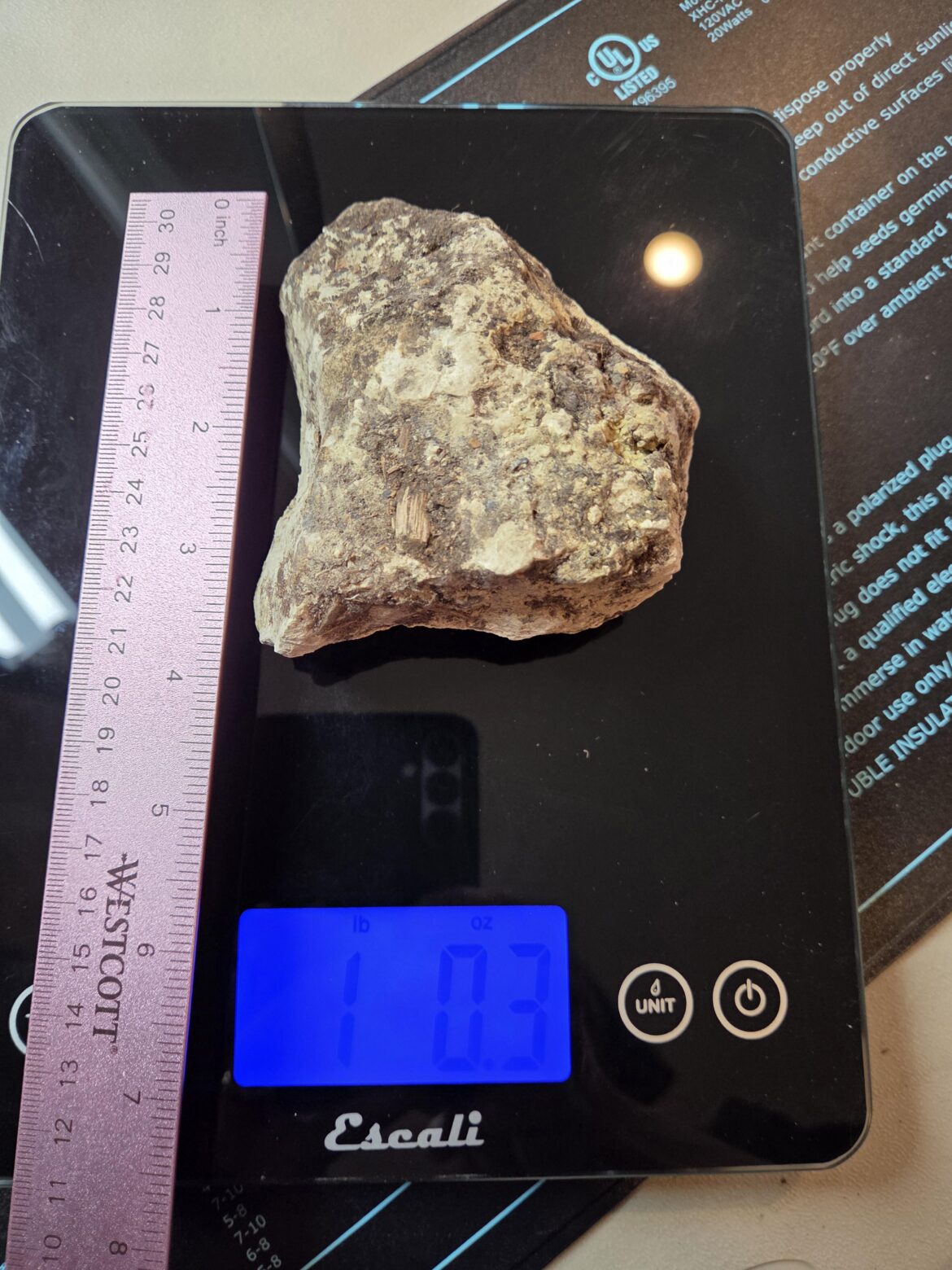 Has anyone found "rocks" in a bag of Miracle Grow organic potting mix? I always expect a certain number of stones in a bag, but today I found this "rock". 1.3 pounds. (My husband is holding the ruler, it's not included in the weight total. )