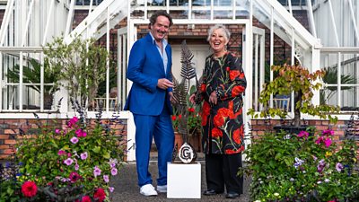 Diarmuid Gavin and Carol Klein standing with the trophy surrounded by plants and flowers
