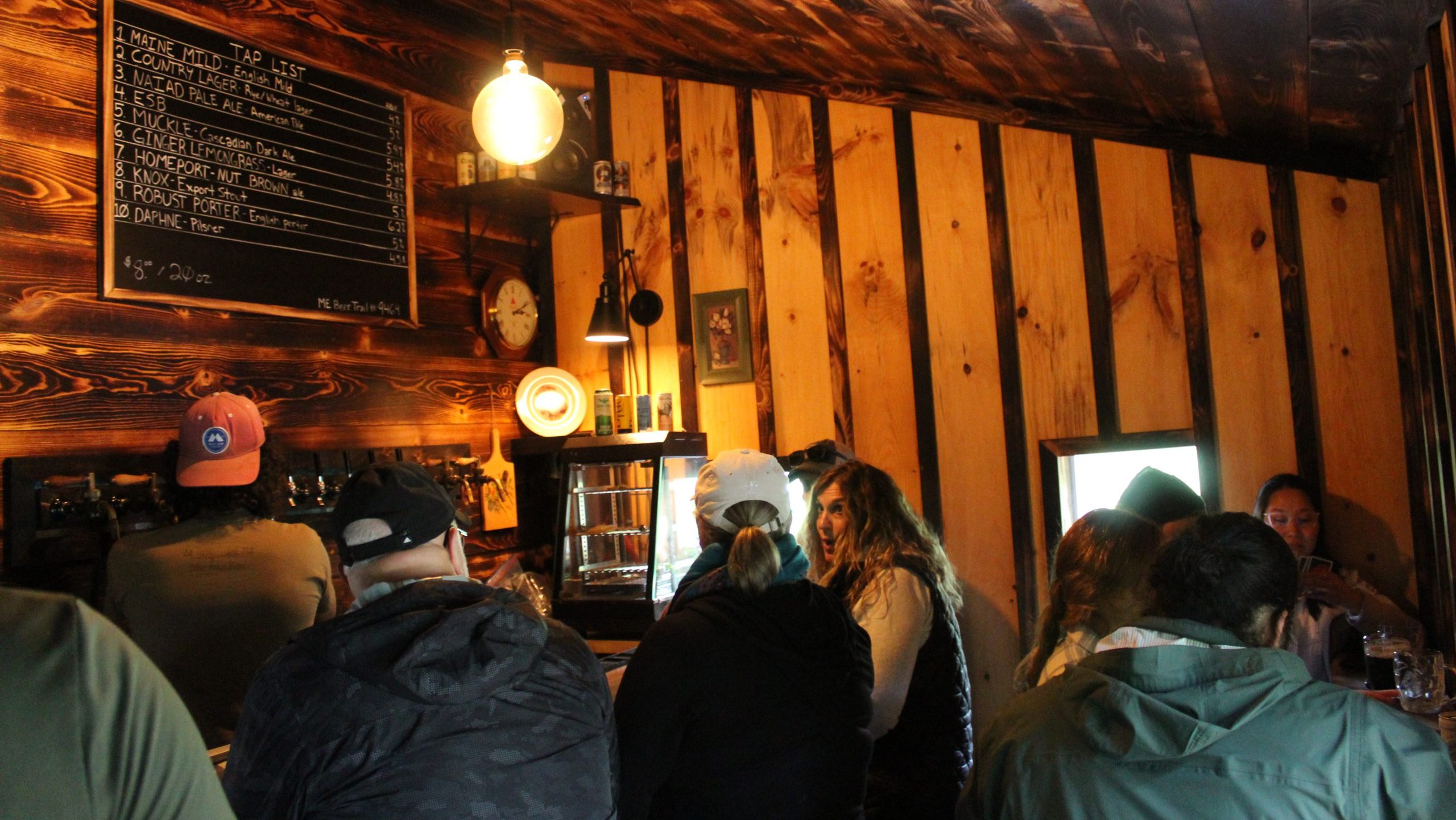 A room has wood siding and people in it.