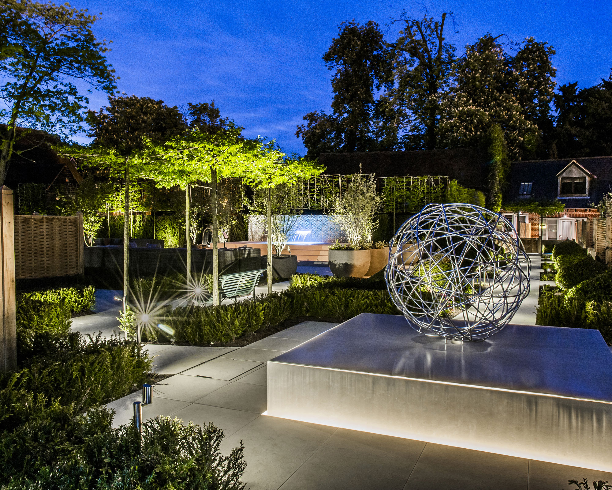 parasol pleached trees with lighting in modern garden