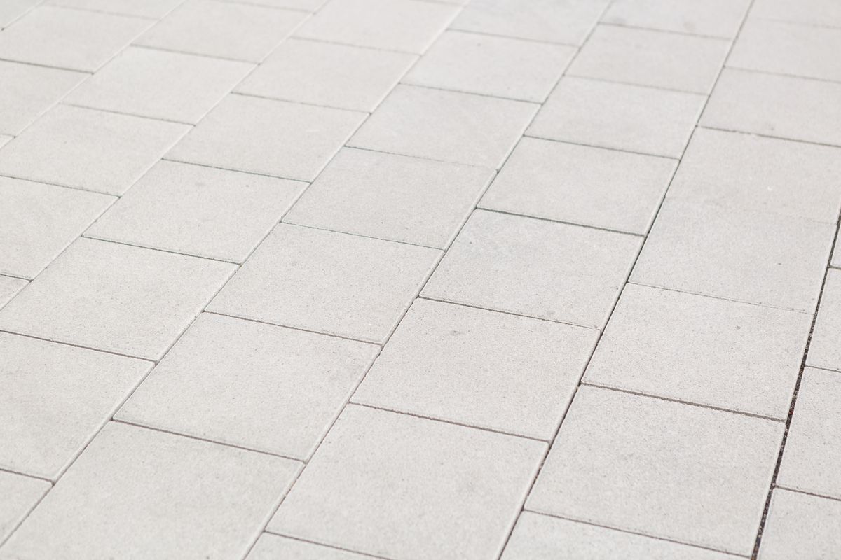 Background texture of square white paving tiles in a receding oblique angle full frame view