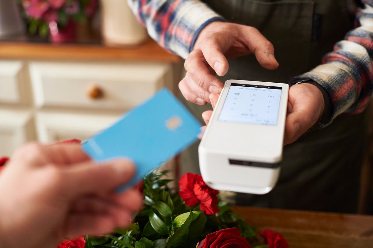 male florist taking payment for a flower arrangement
